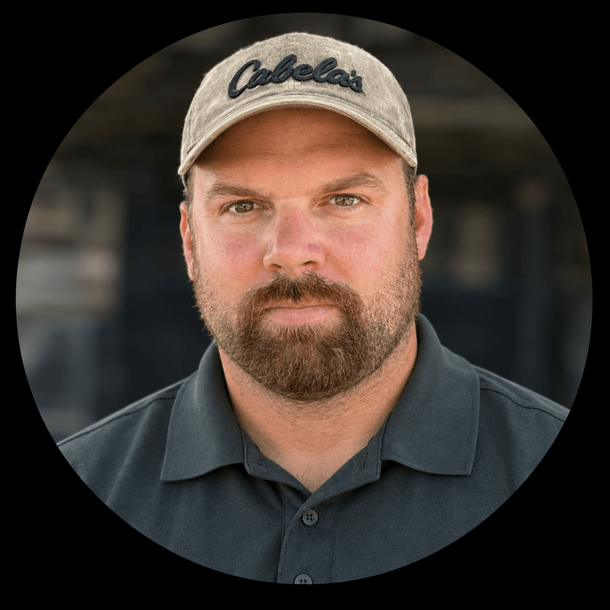 Bearded man wearing tan Cabela's hat and grey polo shirt in a circular portrait.