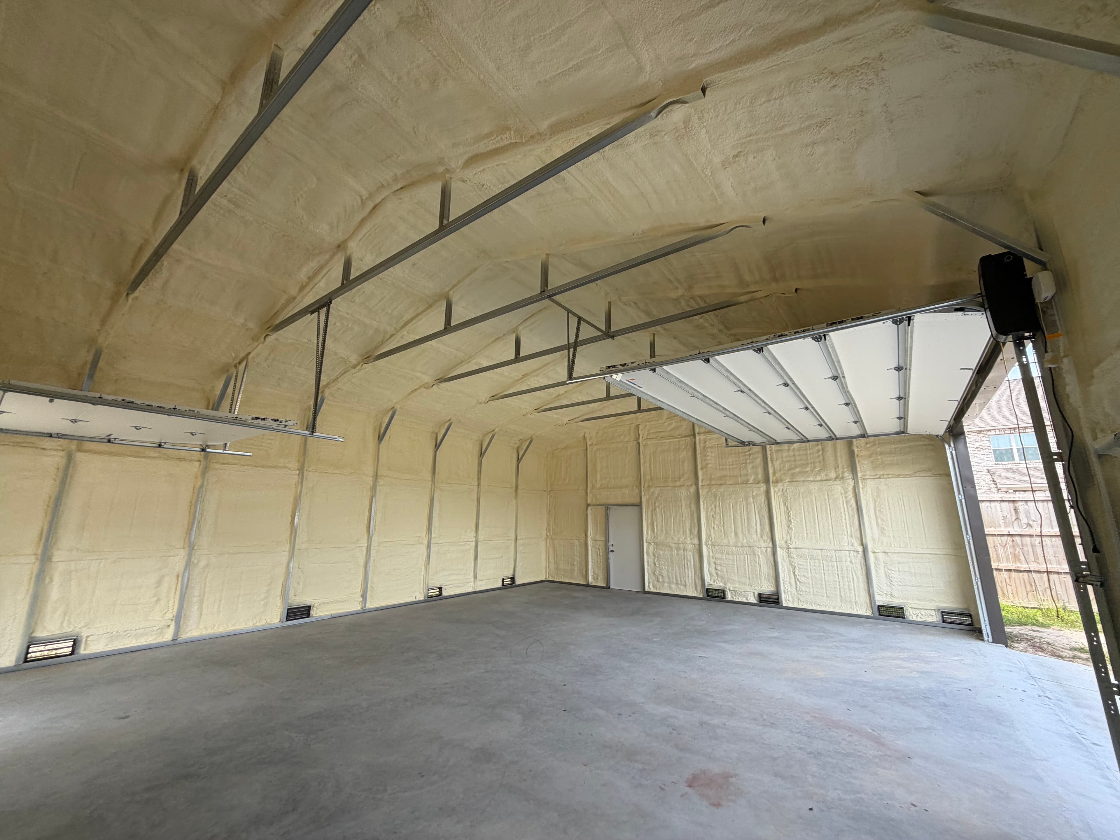 Empty building interior with yellow spray foam insulation on the walls and curved ceiling.